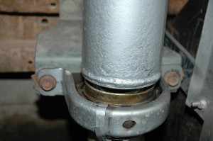 The carrier bearing is bolted to the frame and supports the driveshaft and the CV joint.