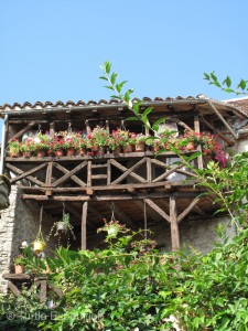 Flower-draped balconies tilt over shops and cafés.