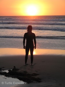 A lone surfer watches the Spanish sun melt into the Atlantic.