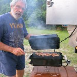 Our compact Weber Go-Anywhere BBQ fits on a table on the side of the bumper and hooks up to our propane tank via a quick disconnect.