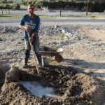 Building an addition to his little garage using the standard method of construction in this part of the world, mud, sticks and stacked stones.