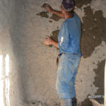 The father was adding mud to the walls of his new building.
