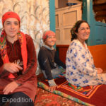 Mom, oldest sister and the magic girl pose for a picture in the main part of their house.