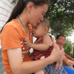 A young mother comforts her child, and you may notice there is no diaper. It’s the Chinese way.