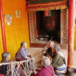 Old Tibetan Women were mending a bell pull rope at their village temple.