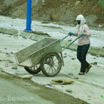 Plastic sheets covered the unfinished roadbed to protect it. The sheets were weighted down by thousands of rocks, each placed by hand, one at a time. Cheap labor?