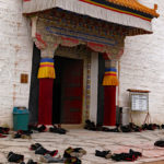 Monks gathered for prayer in one of the main temples leaving their shoes outside.