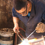 This metal smith was busy working out of his garage.