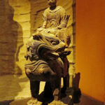 A guard sitting on a royal lion
