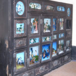 An antique closet was decorated with many paintings.