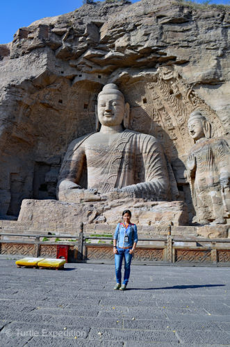 Green is standing in front of the largest outdoor Buddha at the Yungang Grottoes.