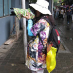 A Chinese tourist is protecting her camera from the rain.