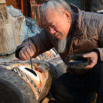 After carving his sculptures, Mr Kim Jong-heung adds the final color touches.
